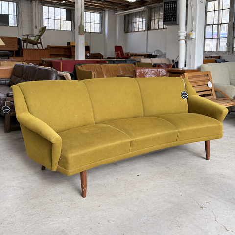 Vintage Danish curved upholstered sofa — showroom view