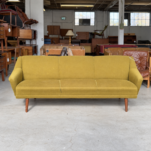 Vintage Danish curved upholstered sofa — showroom view
