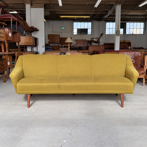 Vintage Danish curved upholstered sofa — showroom view