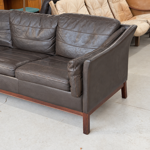 Stouby dark leather three-seater sofa — right outer arm and leg detail